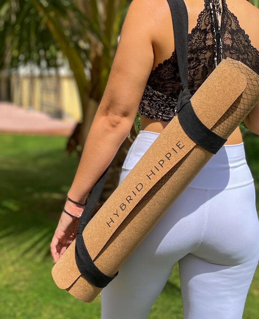 Woman carrying a Hybrid Hippie Cork Yoga Mat with an organic cotton strap